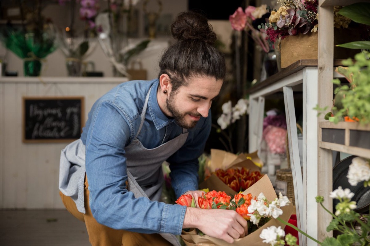 Fleuriste préparant un bouquet dans sa boutique